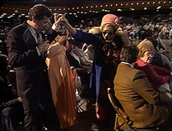 Photo of Peter Popoff helping a woman out of a wheelchair